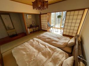 北斗市HOKUTO SATOYAMA BASE的一间卧室,卧室内配有一张大床