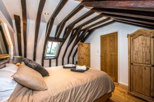 比勒瑞卡Beautiful grade II listed 4 bed Victorian Conversion - Billericay Essex的一间卧室设有一张带木梁的大床