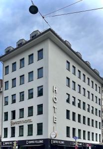 慕尼黑Bayer's City Hotel的白色的建筑,旁边标有标志