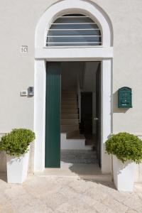 布林迪西Apulian House的一座带绿色门和楼梯的建筑