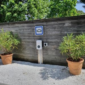 拉波勒Logis Hotel La Closerie的两株植物围栏前的蓝色标志