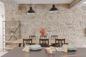 拉科鲁尼亚Central Square Deluxe Apartment的一间设有桌子和石墙的用餐室