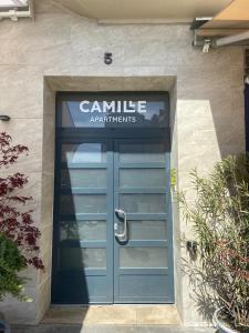 布达佩斯Camille Apartmanhouse的一座建筑,上面有蓝色的门,上面有标志