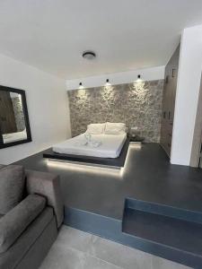 埃尔米奥尼Rock N Sun - Brand new apartment in Ermioni的一间卧室配有一张床和一个沙发