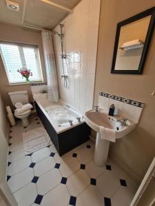 斯沃德林科特Goodwins' by Spires Accommodation a comfortable place to stay close to Burton-upon-Trent的带浴缸、盥洗盆和卫生间的浴室