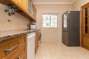 曼塔罗塔Villa Oriente by ALGARVEMANTA的厨房配有不锈钢冰箱和木制橱柜