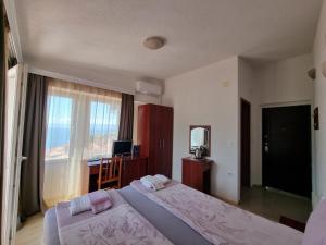 奥赫里德马斯卡斯特罗别墅酒店的一间卧室设有两张床、一张桌子和一个窗口。