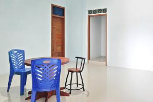 Tua PejatPrima Homestay Mentawai Mitra RedDoorz的一张桌子和两张蓝色椅子