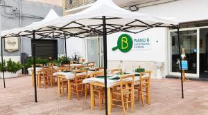 阿韦特拉纳B&b Giadà的一间设有桌椅的白色遮阳伞下的餐厅