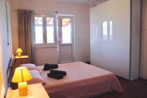 LukaApartment VistaMare Croatia的一间卧室设有两张床、一盏灯和一扇窗户。