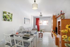 圭马尔Apartamento Puertito Guimar的厨房以及带桌椅的起居室。