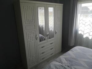 卢萨卡Sheila's Cottage的卧室配有白色橱柜和1张床