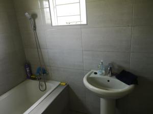 卢萨卡Sheila's Cottage的白色的浴室设有水槽、浴缸和水槽。