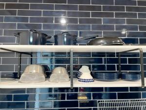佐世保99Stay Sasebo SGx的配有锅碗瓢盆和盘子的厨房架