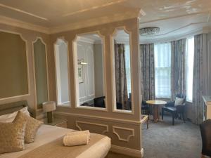 泰恩河畔纽卡斯尔皮尔喀里多尼亚酒店的一间卧室配有一张床和一面大镜子