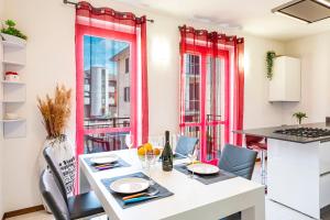 拉韦纳蓬泰特雷萨Tresa Bay House - Lugano Lake的厨房设有红色窗户和桌椅