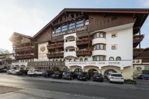 蒂罗尔-泽费尔德Das Kaltschmid - Familotel Tirol的一座大型建筑,前面有汽车停放