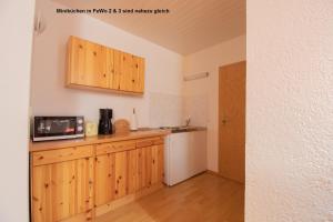 于克里茨Dünenhaus Fewos - Zum Strand 50m的厨房配有木制橱柜和白色冰箱。
