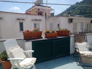 伊斯基亚Appartamento Iasolino的阳台配有椅子和盆栽植物