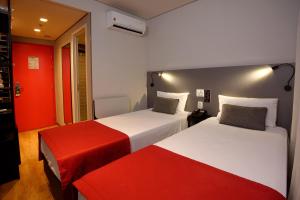 圣保罗Golden Tower Express Berrini by Fênix Hotéis的红色和白色的客房内的两张床