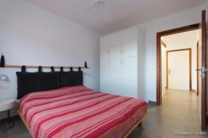 明德卢Seafront Holiday House on the Mindelo Bay的一间卧室配有一张带红色条纹毯子的床