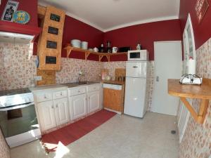奥德赛克斯Carlo's Beach Guest House的一间厨房,配有白色家电和红色墙壁