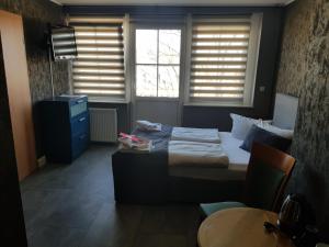 爱尔福特阿特-埃尔福特酒店的一间卧室设有床、两个窗户和一张桌子