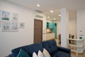 卡斯特拉玛雷帝斯达比亚Charme en Bleu的一间带蓝色沙发的客厅和一间厨房
