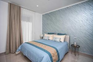 卡斯特拉玛雷帝斯达比亚Charme en Bleu的一间卧室配有一张大床,提供蓝色的床单和枕头