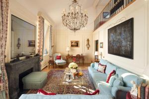 日内瓦Beau-Rivage Genève的客厅配有蓝色的沙发和吊灯。
