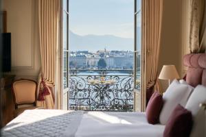 日内瓦Beau-Rivage Genève的酒店客房设有一张床,享有阳台的景色