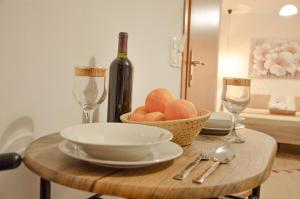 圣加利尼Vel Boutique Suites的一张桌子,上面放着一碗水果和一瓶葡萄酒