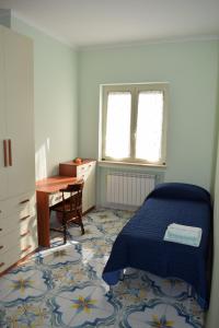 瓜迪亚皮耶蒙特泰尔梅Mare e Terme a Guardia Piemontese的一间卧室配有一张床、一张桌子和一张桌子