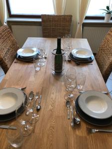 NeefFerienhaus Treis的一张带盘子和玻璃杯的木桌和一瓶葡萄酒