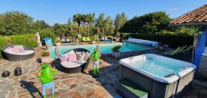 Saint-Saud-Lacoussière圣雅克酒店的庭院内一个带按摩浴缸的游泳池