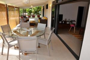 普纳奥亚Appartement Villa Taina piscine的一间设有玻璃桌和椅子的用餐室