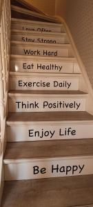 德帕内Kind -& diervriendelijk huisje的楼梯间,上面有标语,表示每天努力工作,吃得健康