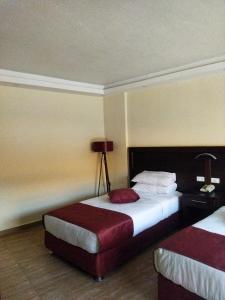 瓦迪穆萨Rendezvous hotel petra的酒店客房,设有两张床和一盏灯