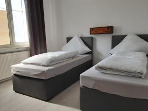 新明斯特Nordunterkunft的客房内的两张床和白色枕头