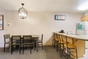 日内瓦湖廷伯里奇别墅与水上乐园酒店的厨房配有桌椅和水槽。