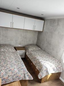厄扎森Gemütliches Landhauswohnen rent-by-seibold的配有白色橱柜的小客房内的两张床