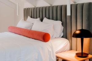 帕尔加Tramonto Maisonettes & Suites的床上的橙色枕头和白色枕头
