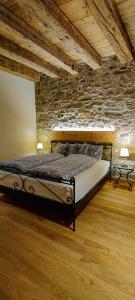 罗蒙Hôtel St-Georges Romont的一间卧室设有一张床和石墙