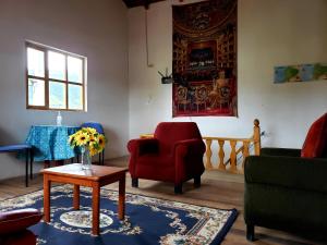 奥塔瓦洛Hosteria Rose Cottage的客厅配有椅子和一张带花瓶的桌子