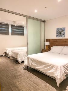 巴兰基亚Gz Tower Apartamento Barranquilla的卧室内的两张床,配有白色床单