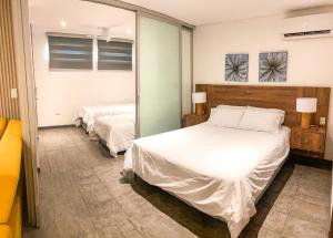 巴兰基亚Gz Tower Apartamento Barranquilla的一间卧室配有两张床和镜子