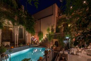 马拉喀什塞邦里亚德宫庭院旅馆的夜间在庭院里的一个游泳池
