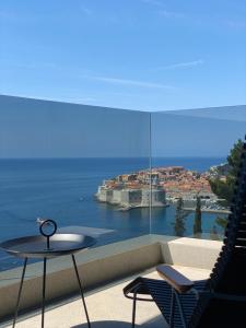 杜布罗夫尼克New&Luxury Apartment with an Outstanding View - Bombii Blue的阳台配有桌子,享有海景。