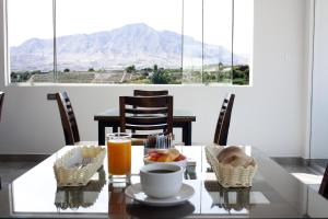 莫克瓜Hotel Tierra del Sol Moquegua的一张桌子,上面放着一碗食物和一杯橙汁