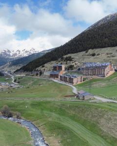 索尔德乌Apartamento Luxury en Bordes d'Envalira, Andorra的山丘上的酒店,有河流和山脉